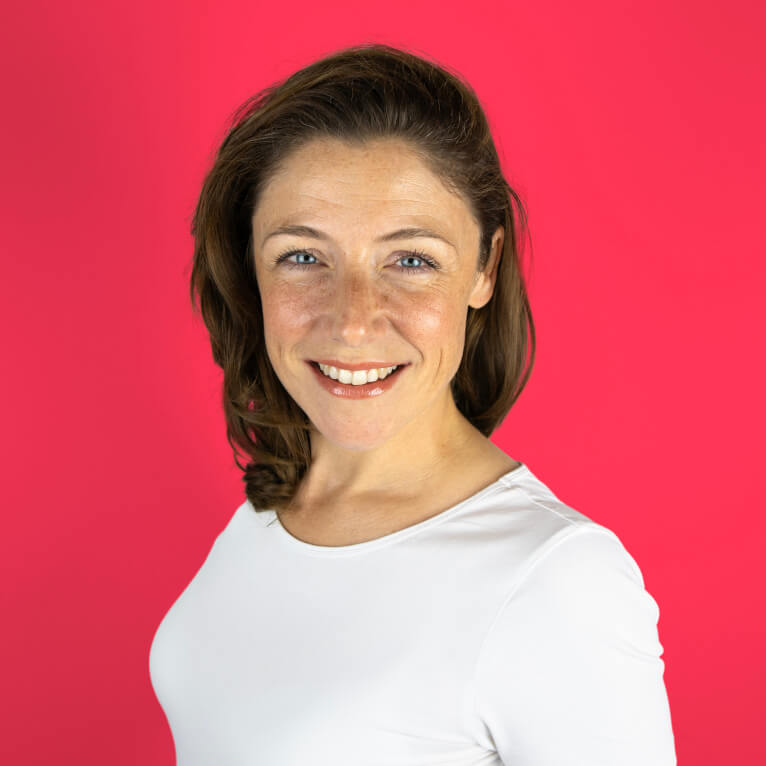 Porträt von Antonia, Mitarbeiterin im Logiktik-Team bei foodloose, lachend vor rotem Hintergrund.